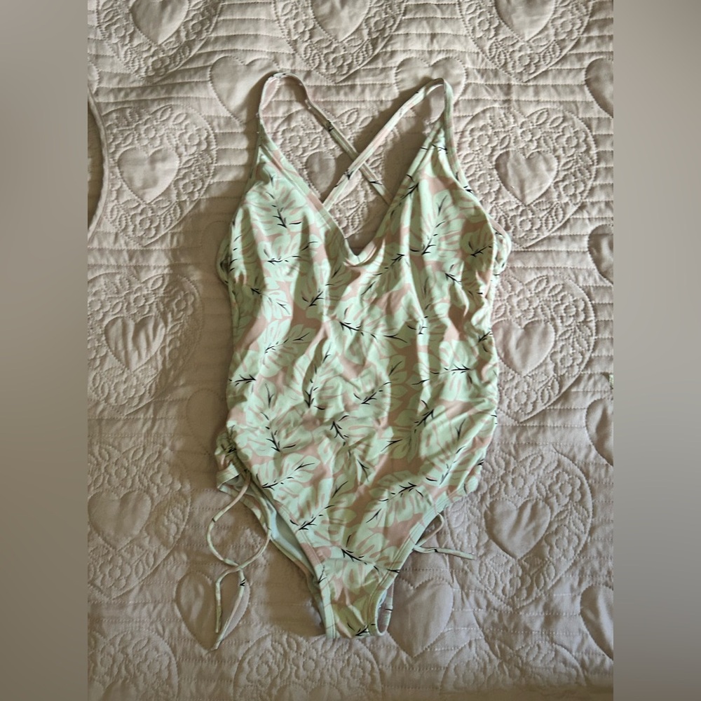 A flower swim suit with pink and white flowers and black leaves